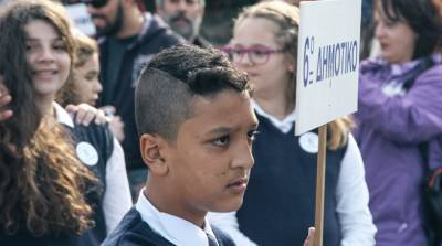 Αφγανός μαθητής αντί της σημαίας κράτησε την ταμπέλα του σχολείου (Φωτογραφίες)